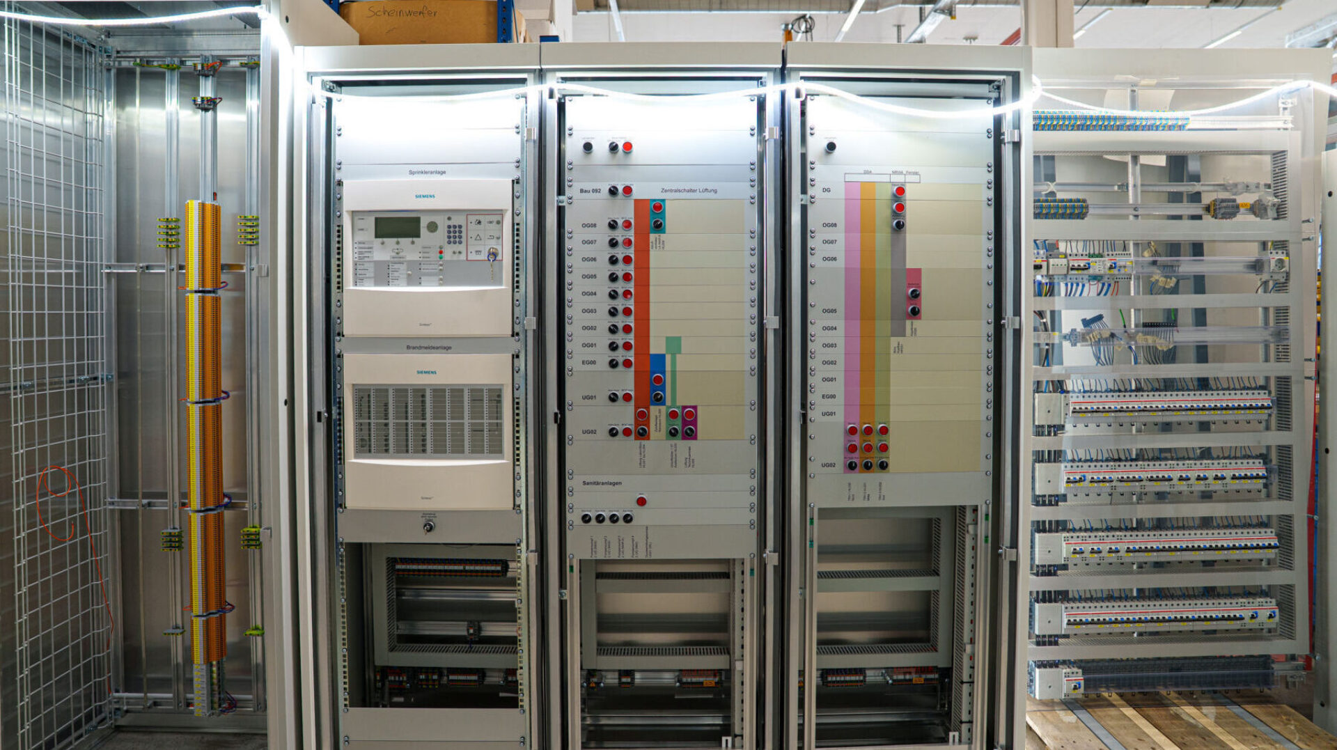 Ein offener Schaltschrank mit verschiedenen technischen Komponenten und Kabeln.