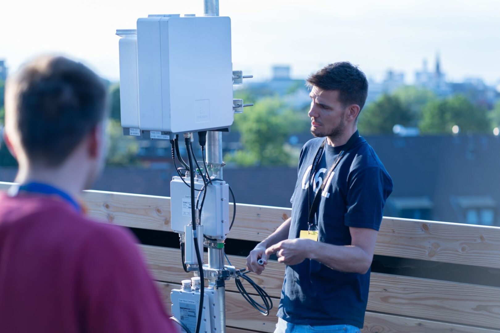 Ein Mann erklärt eine technische Anlage auf einem Dach.