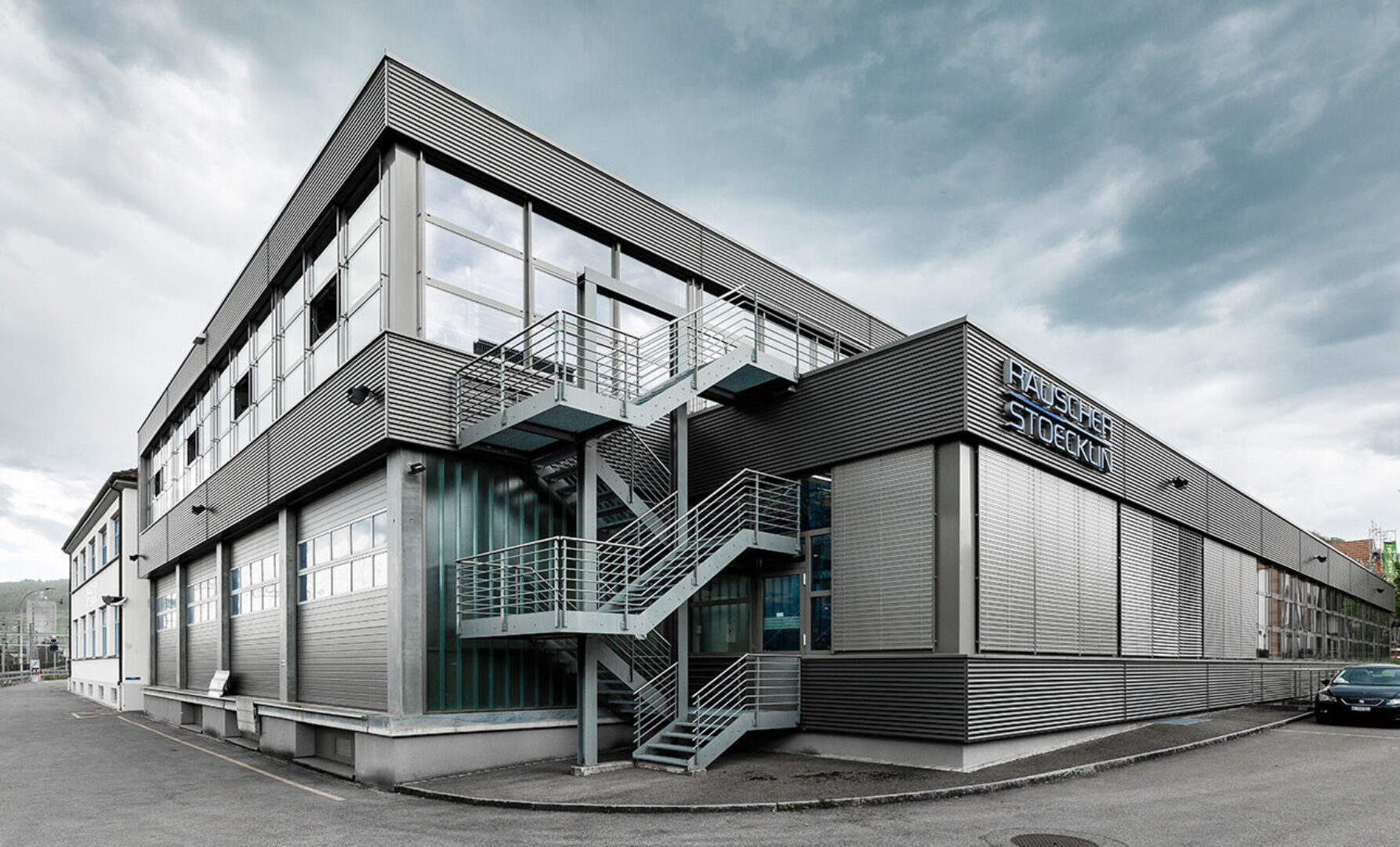 Moderne Industriehalle mit Metallverkleidung und Treppen.