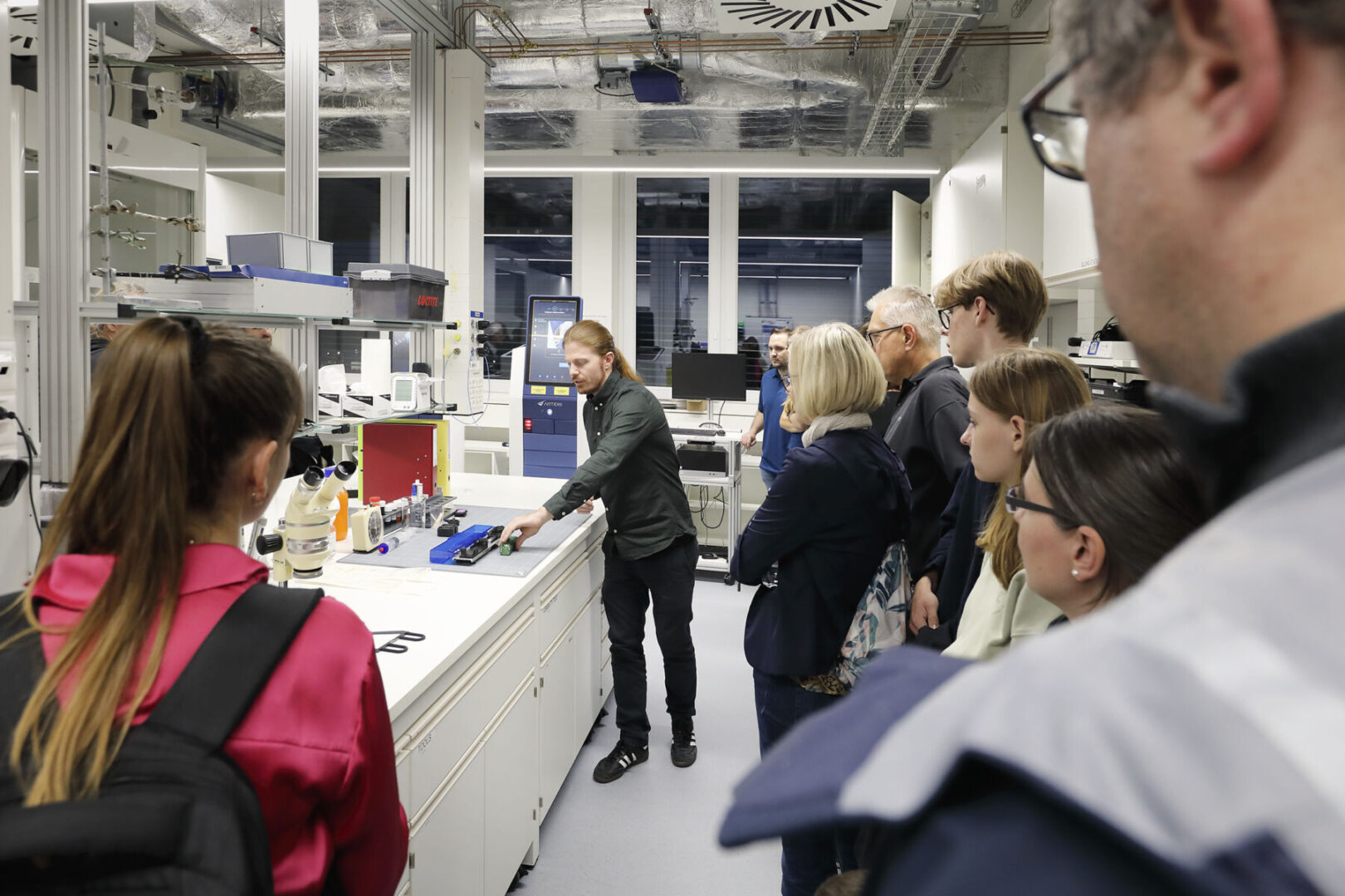 Eine Gruppe von Menschen beobachtet eine Person in einem Labor.