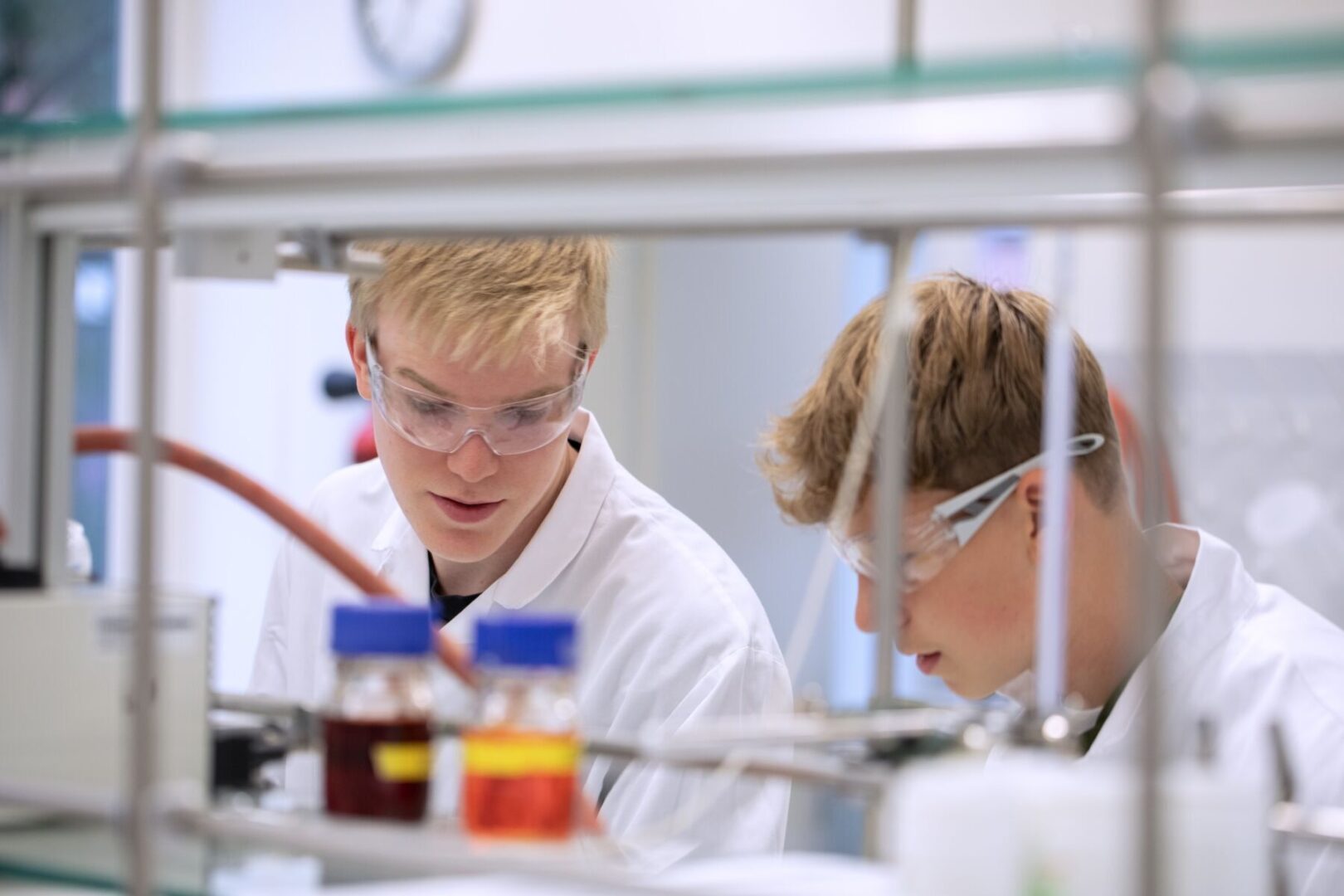 Zwei Personen in weißen Laborkitteln führen ein Experiment durch.