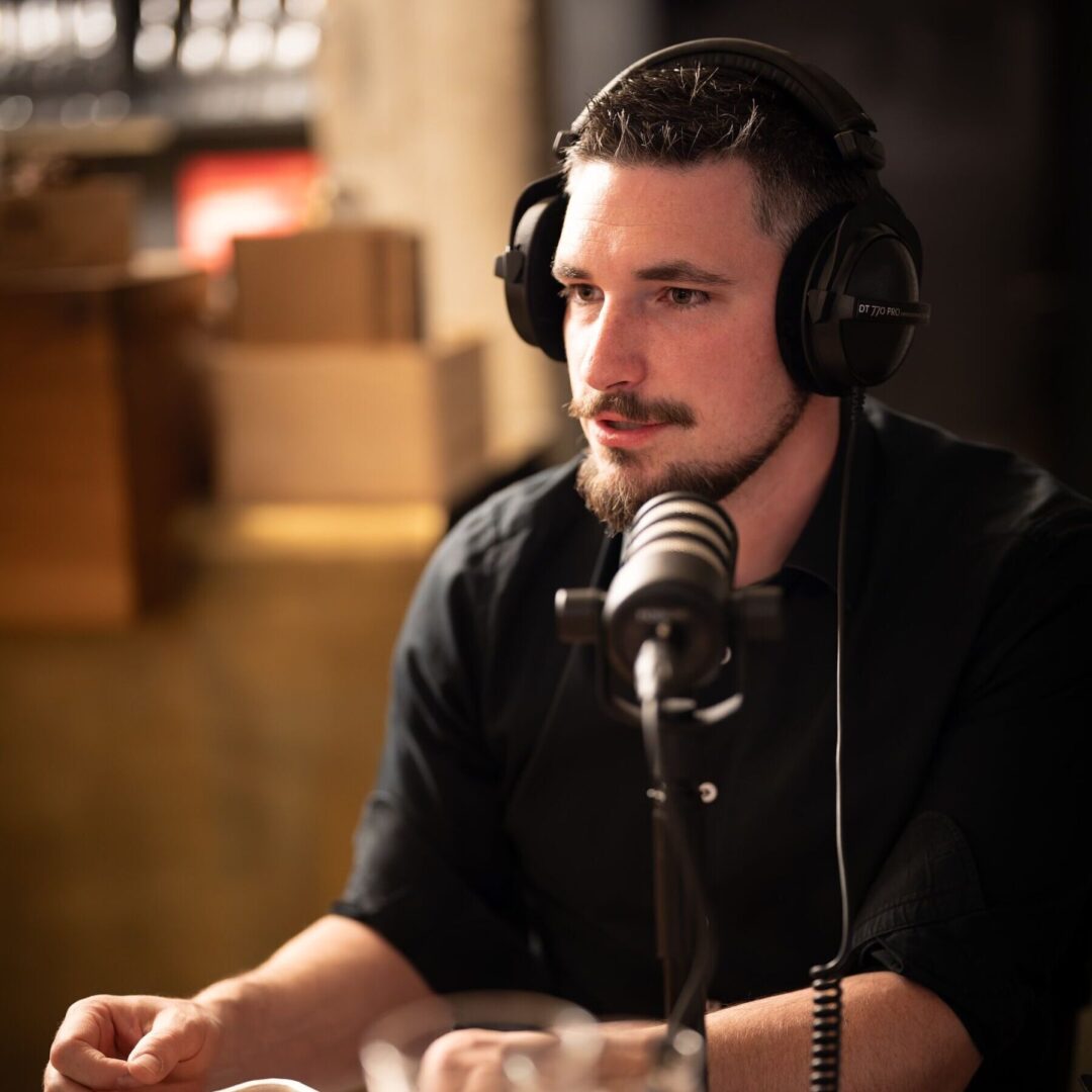 Ein Mann mit Kopfhörern spricht in ein Mikrofon.